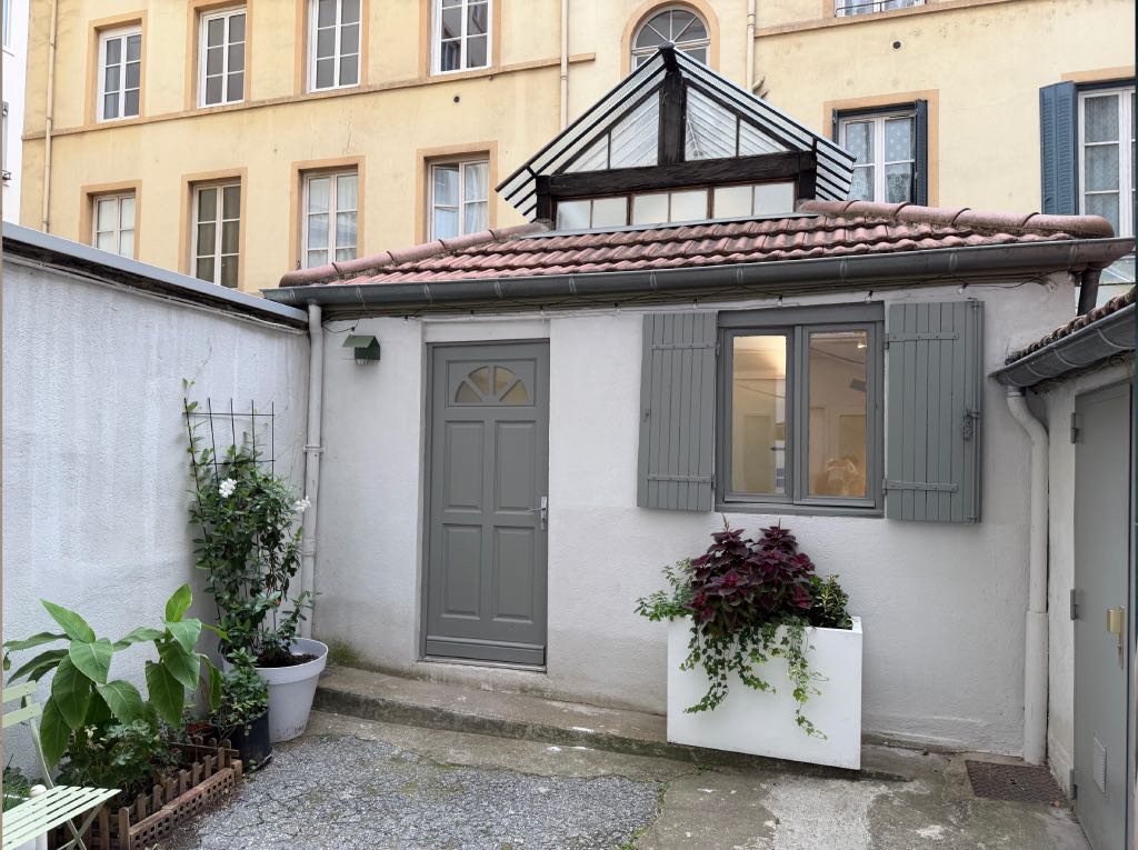 Cour extérieure végétalisée et aménagée en espace de détente pour une petite maison de 17m² à Lyon.
