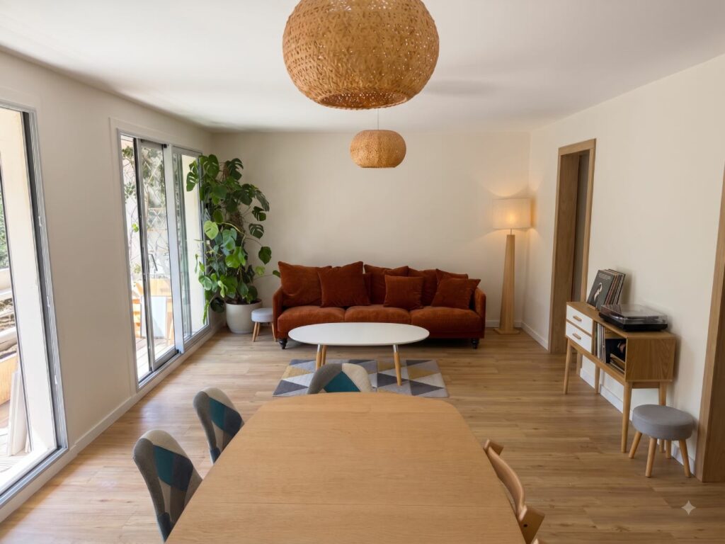 Vaste espace salon chaleureux aménagé côté Sud après l'agrandissement de la pièce de vie lors de la rénovation à Lyon 5.